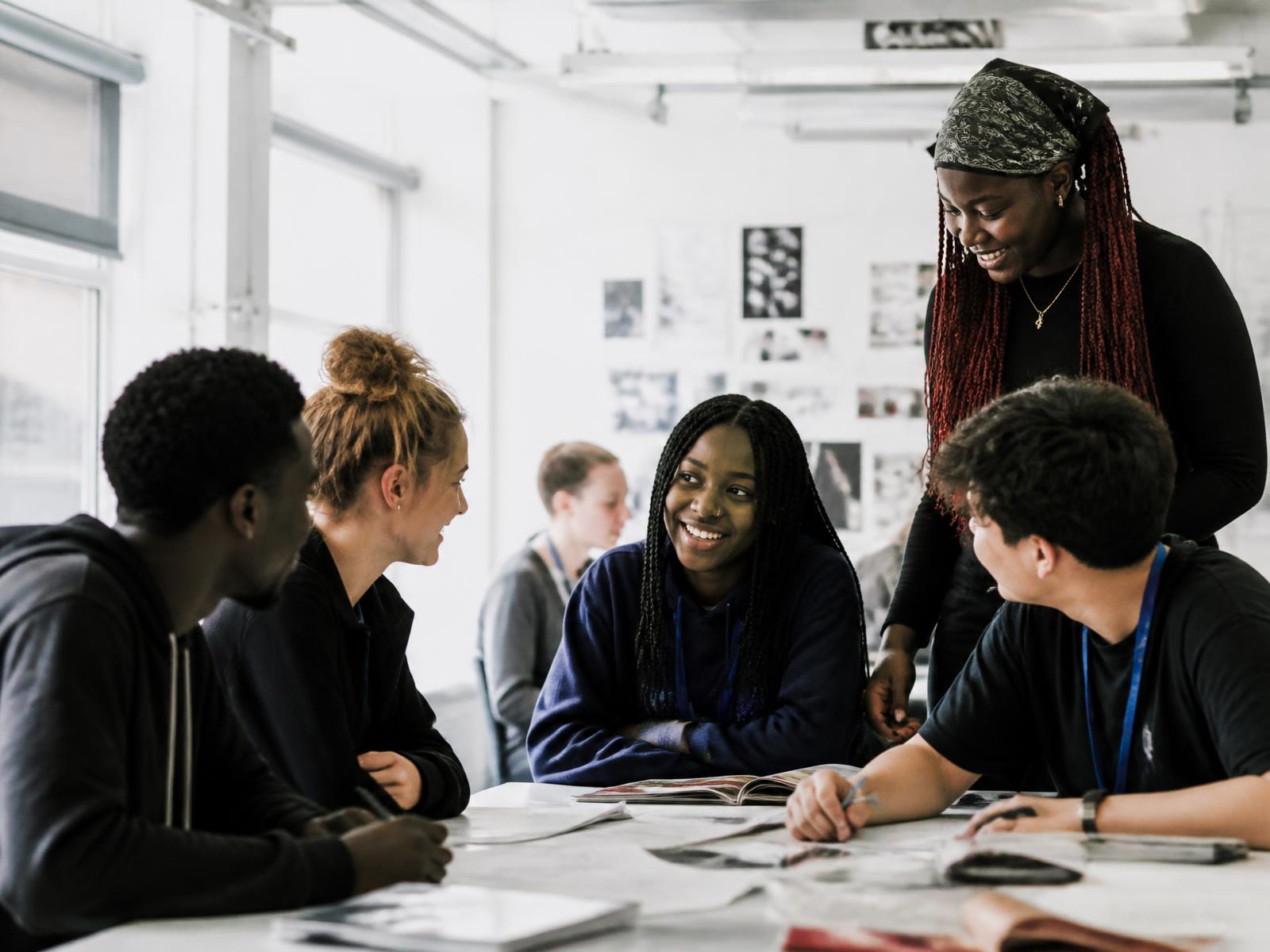 Young people talking and working together in a bright creative workshop